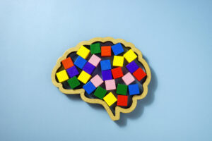 Neurodiversity concept showing a brain shape and colourful wooden cubes.