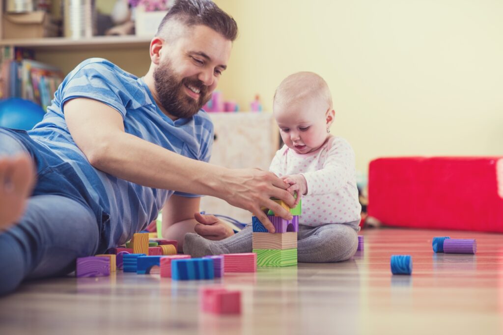 Dad playing building blocks with his young daughter
